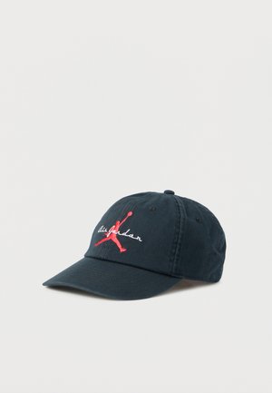 Casquette de baseball en coton bleu marine avec une visière courbée, arborant un logo Jumpman rouge brodé et le texte blanc « Air Jordan » sur le devant.