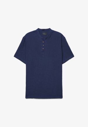 Chemise bleu marine à manches courtes avec trois boutons marron sur un col rond et tissu texturé.