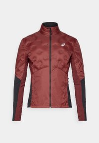 Giacca isolante rossa con motivi texture arrotondati, maniche nere, colletto alto e zip frontale. Presenta il logo sul petto.