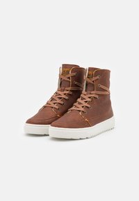 Brown leather high-top sneakers with white rubber soles, featuring round laces and a logo tag on the tongue. Simple, textured design.