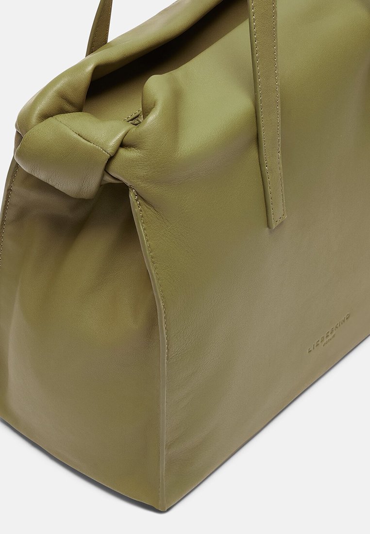 Zielona oliwkowa skórzana torebka o ustrukturyzowanym kształcie, z detalem w postaci zawiązania, gładką powierzchnią i wytłoczonym logo z boku.