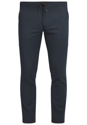 Pantalons fuselés bleu marine en tissu texturé. Dotés d'une taille avec cordon de serrage réglable et de poches latérales. Fini lisse, coupe ajustée.