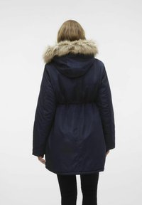 Granatowa puchowa kurtka z kapturem podszytym futrem i elastyczną talią, z długimi rękawami i sięgająca do kolan, o gładkiej fakturze i prostym wzornictwie.