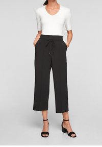 Pantalons noirs taille haute avec une coupe ample, dotés d'une taille à cordon de serrage et de poches latérales. Tissu lisse avec une silhouette à jambe droite.