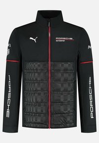 Czarna kurtka z czerwonymi akcentami, z zamkiem błyskawicznym, teksturowanymi poduszkowanymi obszarami oraz białymi logo Porsche i Pumy na rękawach.