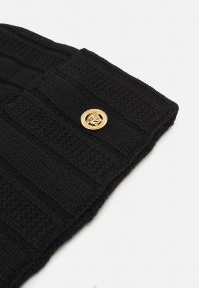 Écharpe en maille noire avec un design texturé en côtes. Un bouton circulaire en or avec un emblème de lion est fixé pour le détail.