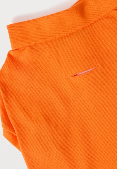 Col et haut du dos d'un polo orange avec une ouverture horizontale pour boutonnière au centre haut du dos.