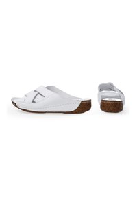 Witte leren slippers met twee overlappende banden. Korken zool zorgt voor textuur en contrast. Open neus ontwerp met een ronde vorm.