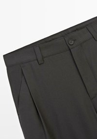 Dunkelgraue Hose mit glatter Textur, ausgestattet mit einem Knopfverschluss, Seitentaschen und einem taillierten Design mit Falten vorne.