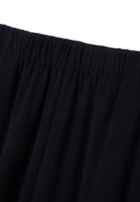 Navyblauwe rok met een elastische tailleband en geplooid materiaal, met een zachte textuur en een gladde afwerking, ontworpen voor comfort en gemak in het dragen.