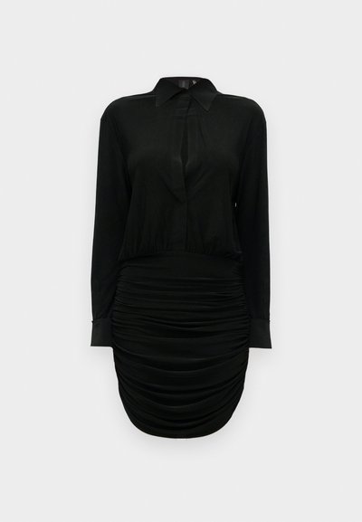 Juoda su ilgomis rankovėmis suknelė su apykakle, raukšlėtu sijonu ir priekyje esančia raktelio formos iškirpte, pateikta ant paprasto balto fono.