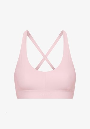 Soutien-gorge de sport rose clair avec une texture lisse, des larges bretelles et un design croisé dans le dos. Comprend un détail de logo sur la bande.