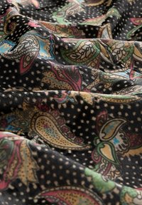 Mustra mustrikangaga mustrit separatse paisley motiividega, mis on säravate värvidega nagu roosa, roheline ja sinine. Pehme tekstuur ja langemistunne.
