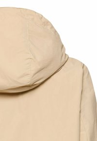 Veste beige légère avec une capuche cousue, vue de dos, mettant en valeur la texture du tissu et les détails des coutures.