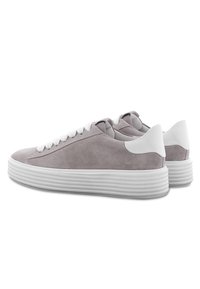 Grå mockaskor med vita gummisulor, med vita snören, rund tå och en slät yta med subtila sömdetaljer.