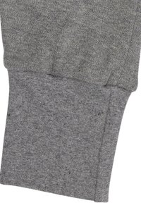 Grijze sweatshirtstof, met een geprofileerde brei en ribgebreide manchetten. Naaddetails zichtbaar aan de zijkant voor een nette afwerking.