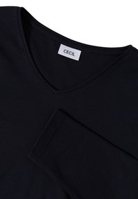 Schwarzes V-Ausschnitt Langarmshirt aus weichem Stoff. Verfügt über ein Etikett mit der Marke "CECIL"; glatte Textur und taillierte Passform.