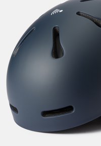 Casque de marine avec une finition mate, comportant des fentes de ventilation et un logo. Surface lisse avec une forme arrondie et des accents renforcés.