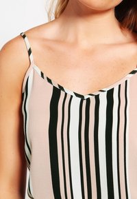 Blusa con spalline caratterizzata da scollatura a V, realizzata in tessuto leggero con strisce verticali in tonalità di rosa, bianco e nero.