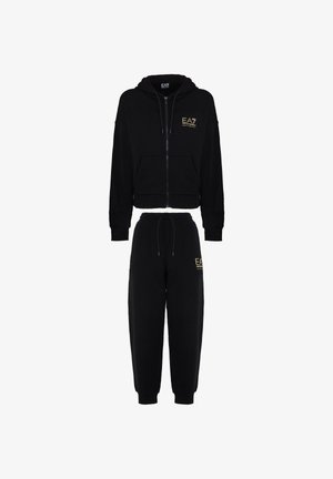 Tuta due pezzi nera in cotone. Giacca con cappuccio e zip, dotata di tasche frontali e logo, abbinata a joggers aderenti con vita elastica e logo.
