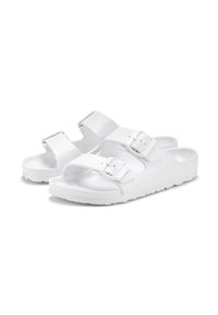 White sandals with two adjustable straps, featuring a textured upper and smooth rubber sole. Minimalist design and secure buckles.