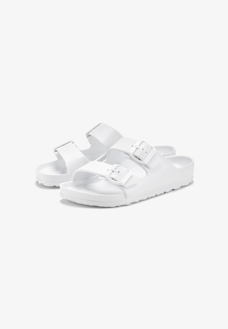 White sandals with two adjustable straps, featuring a textured upper and smooth rubber sole. Minimalist design and secure buckles.