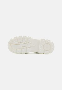 Suola di scarpa in gomma bianca con superficie strutturata caratterizzata da motivi a zigzag e triangolari, marchiata con un logo circolare.