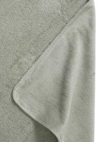 Mjuk grön fleecefilt med en slät yta, med en vikt kant och en enkel, ren design. Inga mönster eller ytterligare accenter.