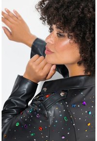 Zwarte leren jas met kleurrijke rhinestones in verschillende vormen en maten, met een klassieke kraag en drukknoopaccenten.