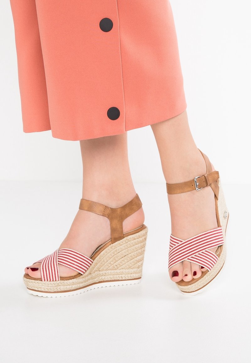 Sandales compensées avec une semelle en jute tissé, des brides en tissu rayé rouge et blanc, et une sangle de cheville en simili cuir marron avec une boucle.