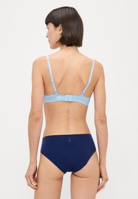 Svetlo modri bra s tankimi naramnicami in temnomočne modre bikini hlačke, oboje iz gladkega materiala. Bra ima vodoravno rebrovanje in zaponko.