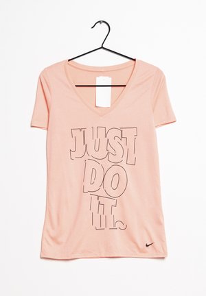 Różowa koszulka z dekoltem w serek od Nike z krótkim rękawem. Posiada czarny napis "JUST DO IT". Wykonana z miękkiego materiału; ma metkę. Czarny logo na dole.
