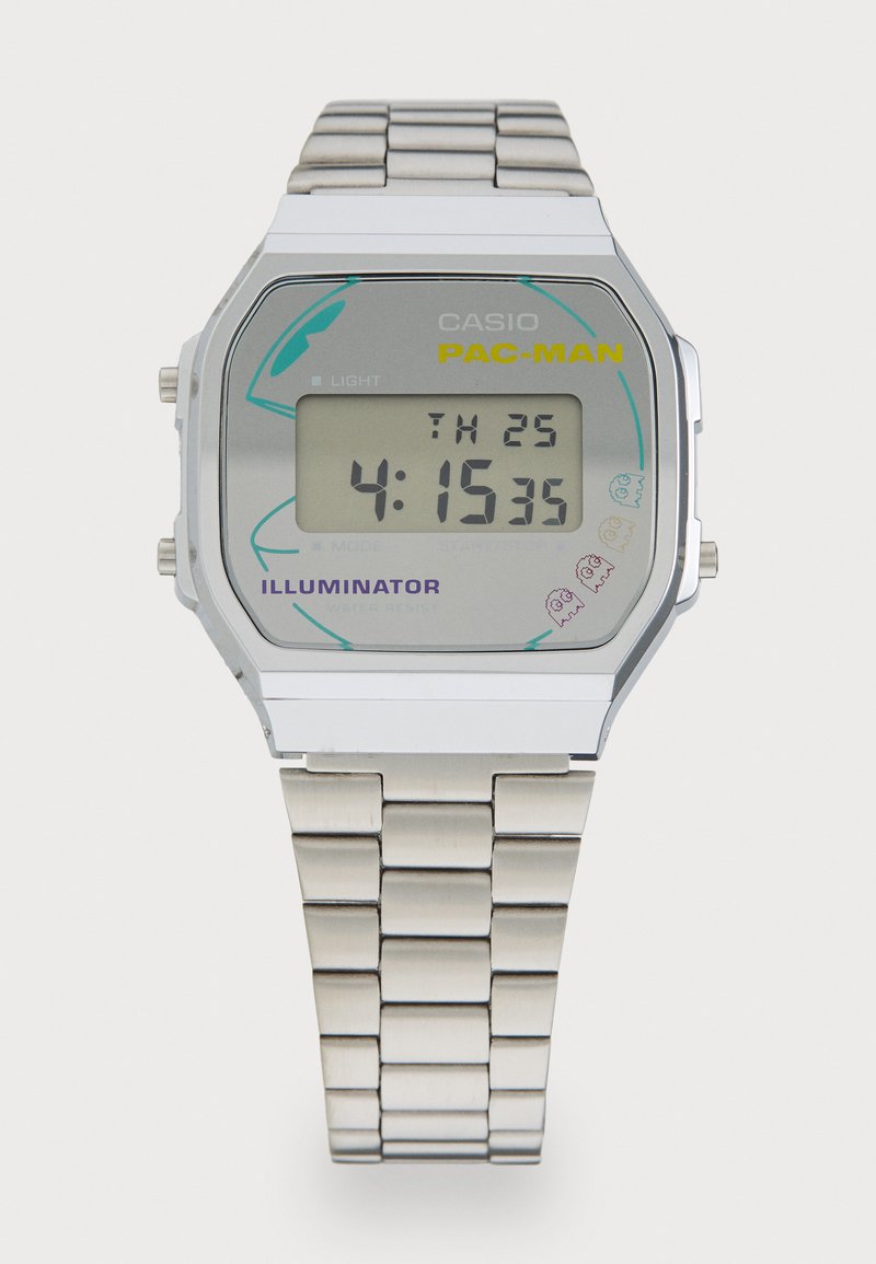 Montre numérique en acier inoxydable argenté avec un cadran rectangulaire affichant un écran LCD gris, des graphismes colorés de PAC-MAN et un bracelet à maillons.