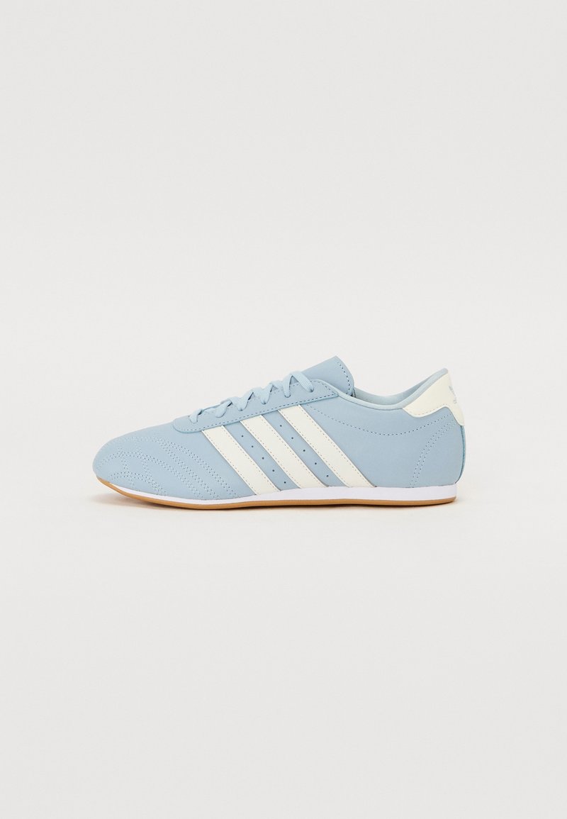 Jasnoniebieski but sportowy z białymi paskami, wykonany z gładkiej skóry, z perforowanym wzorem, zaokrąglonym noskiem i gumową podeszwą.