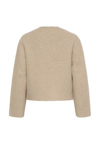 Beige lühike jakk, mis on valmistatud tekstuurist kangast, ümmarguse kaelusega ja pikkade varrukatega, millel on õlavarre õmblused.