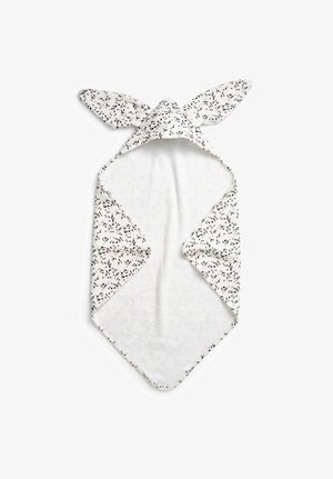 Hooded towel in soft white fabric, featuring black spots and bunny ear design. Textured surface with overlapping triangular ends.