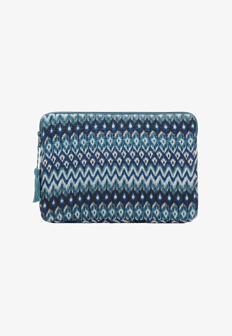 Manchon matelassé pour ordinateur portable avec un motif ikat bleu et marine, doté d'une tirette à pompon, fabriqué à partir d'un tissu à la texture lisse.