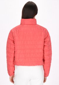 Giacca puff tagliata in corallo, caratterizzata da una texture trapuntata e un colletto alto. Tessuto liscio con una silhouette aderente e polsini elasticizzati.