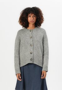 Gray knitted cardigan with a round neckline, five large buttons down the front, and ribbed texture. Worn over a dark, flowy dress.