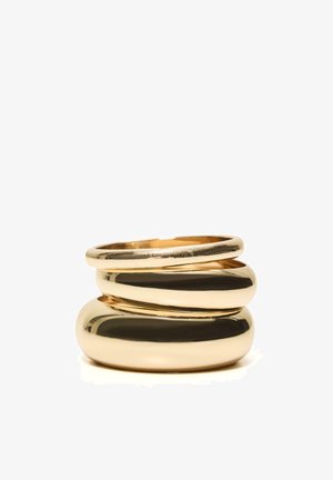 Trei inele aurii strălucitoare suprapuse, cu grosimi diferite, pe fond alb.