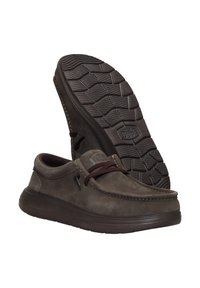 Zapatos de ante marrón tipo mocasín con suelas de goma, que cuentan con una puntera redondeada, cordones de cuero y un patrón de agarre texturizado en la suela.