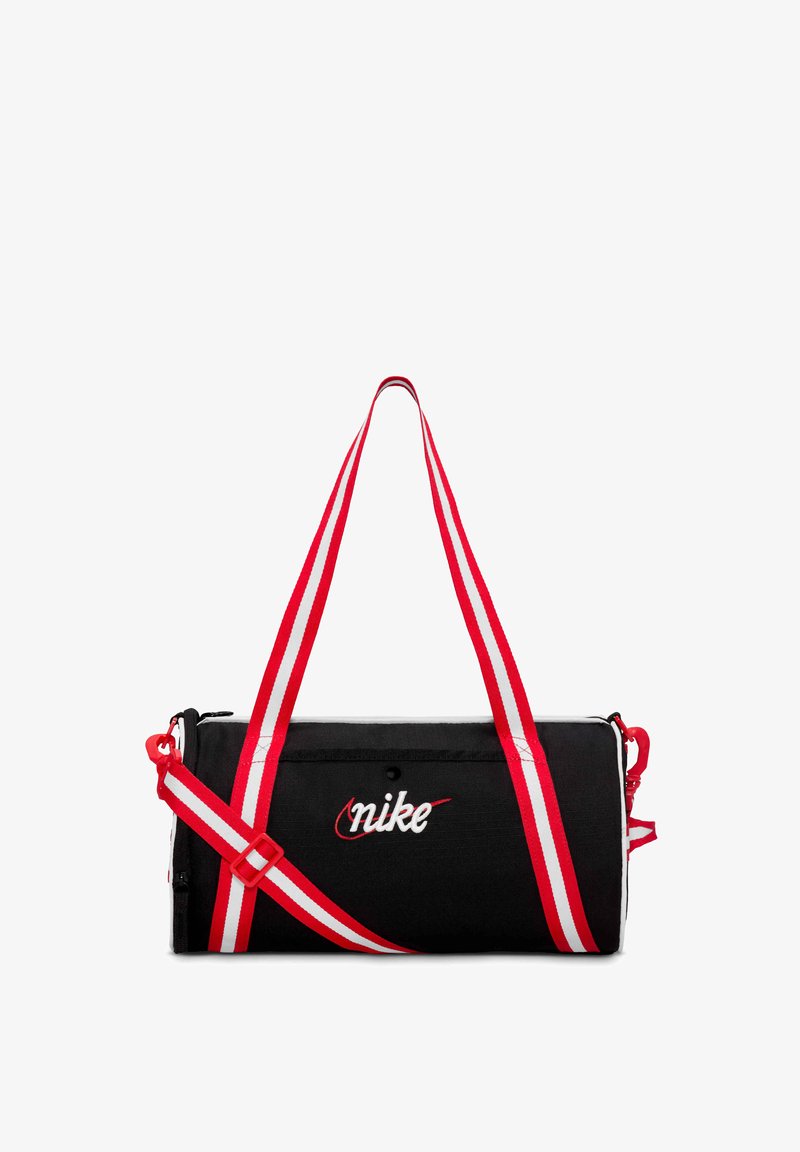 Musta sylinterimäinen Nike-urheilukassi, jossa on punavalkoraidalliset olkahihnat ja kirjailtu Nike-logo edessä.
