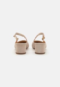 Beige suede block-heeled shoes with back strap, featuring a gold-tone buckle detail and a smooth textured finish.