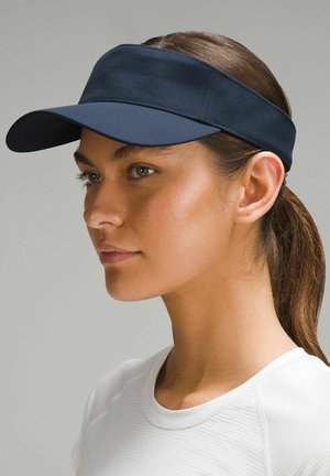 Visière bleu marine en tissu lisse avec une large bordure et une bande ajustable. Présente un design simple avec un minimum de détails de couture.