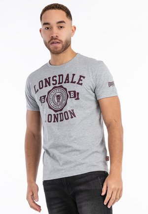 Siva pamučna majica s graficima u tamnocrvenoj boji koji sadrže tekst "Lonsdale London". Kratki rukavi, okrugli izrez, prilagođeni kroj i logo na rukavu.