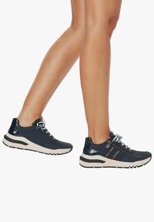 Baskets bleu marine avec une tige en tissu texturé, semelle blanche et accent de fermeture éclair coloré. Comprend un design à lacets et un col rembourré.