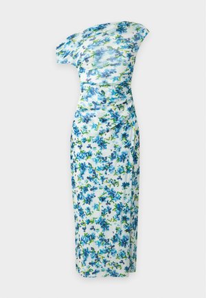 Frau, stehend, trägt ein weißes Midikleid mit blauem Blumenmuster und schulterfreiem Ausschnitt, kombiniert mit weißen Sandalen mit hohen Absätzen.