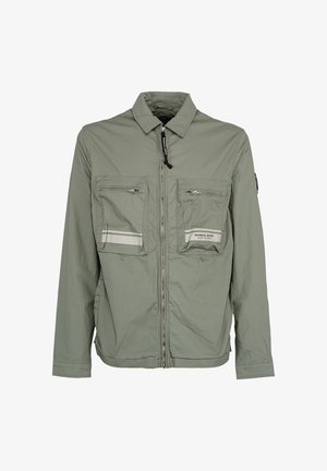 Jasnozielona kurtka na zamek z kołnierzem, dwie duże przednie kieszenie na zamek oraz odblaskowe paski na kieszeniach.