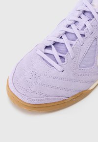 Lila mockasin av suede med meshdetaljer, med rund tå, snörning fram och gummisula. Detaljerad sömnad längs ovandelen.