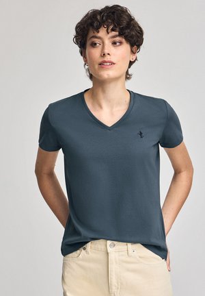 T-shirt V en teinte bleu foncé, fabriqué en tissu doux, avec des manches courtes et un petit logo brodé sur la poitrine gauche.